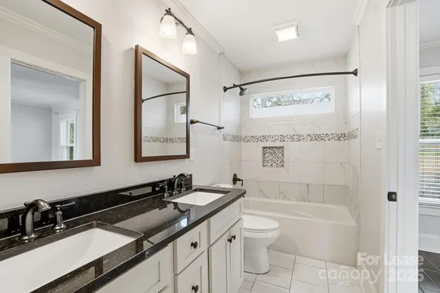 a bathroom with a granite countertop sink mirror toilet and bathtub