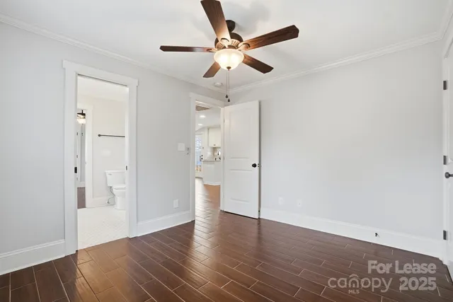 an empty room with wooden floor and ceiling fan