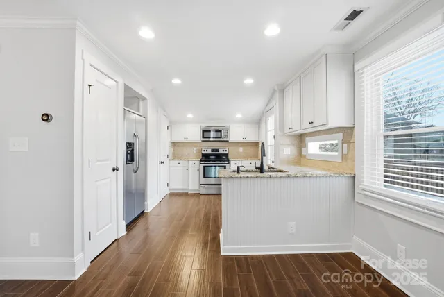 a kitchen with stainless steel appliances granite countertop a refrigerator sink and cabinets