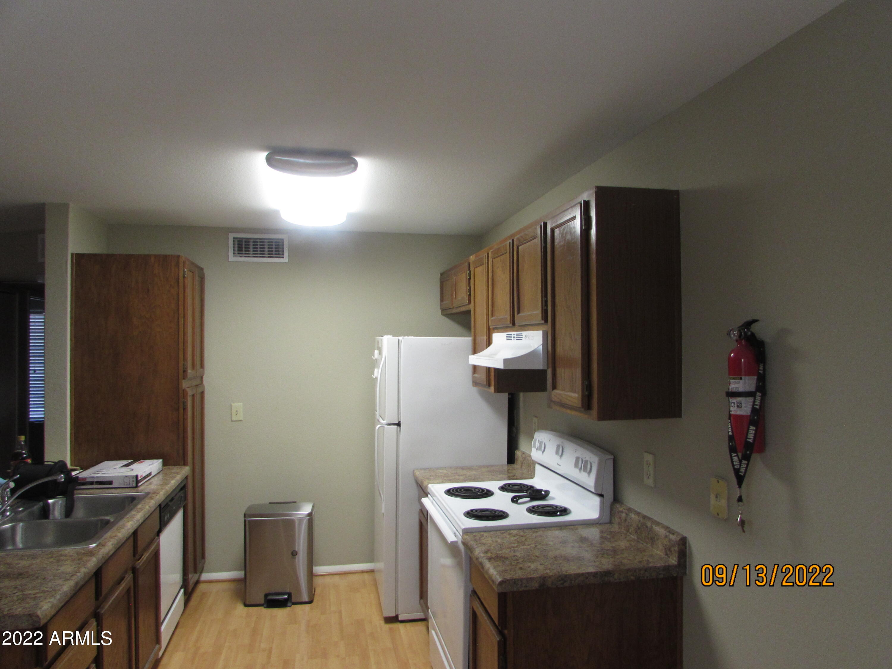 5236 West Peoria Avenue, Unit 115 Glendale, AZ 85302 - Photo 12 of 19 a kitchen with stainless steel appliances granite countertop a stove a sink and a refrigerator