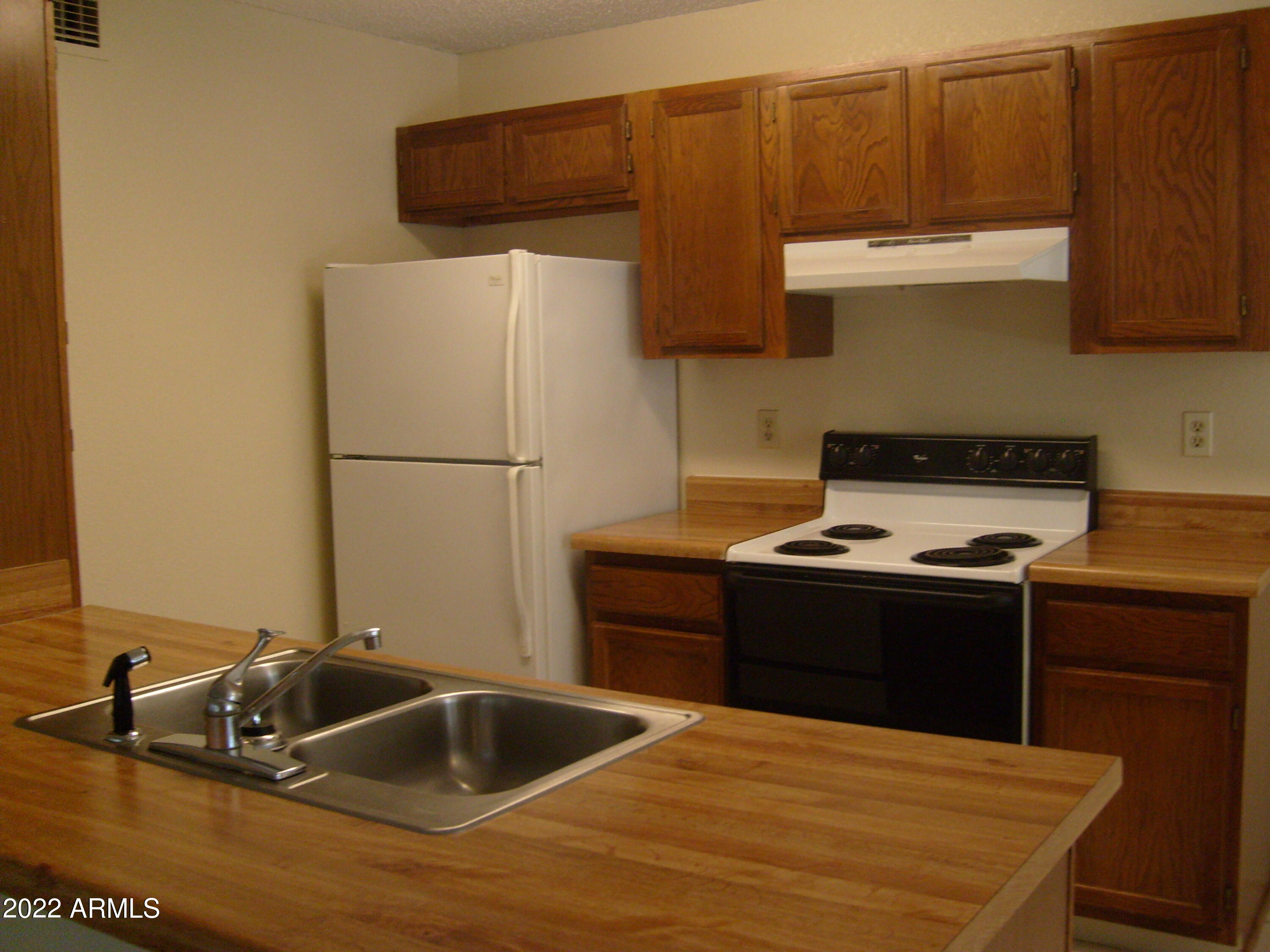 5236 West Peoria Avenue, Unit 115 Glendale, AZ 85302 - Photo 13 of 19 a kitchen with granite countertop a sink and a stove with wooden floor