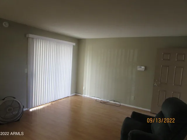 a view of a livingroom with wooden floor and a window
