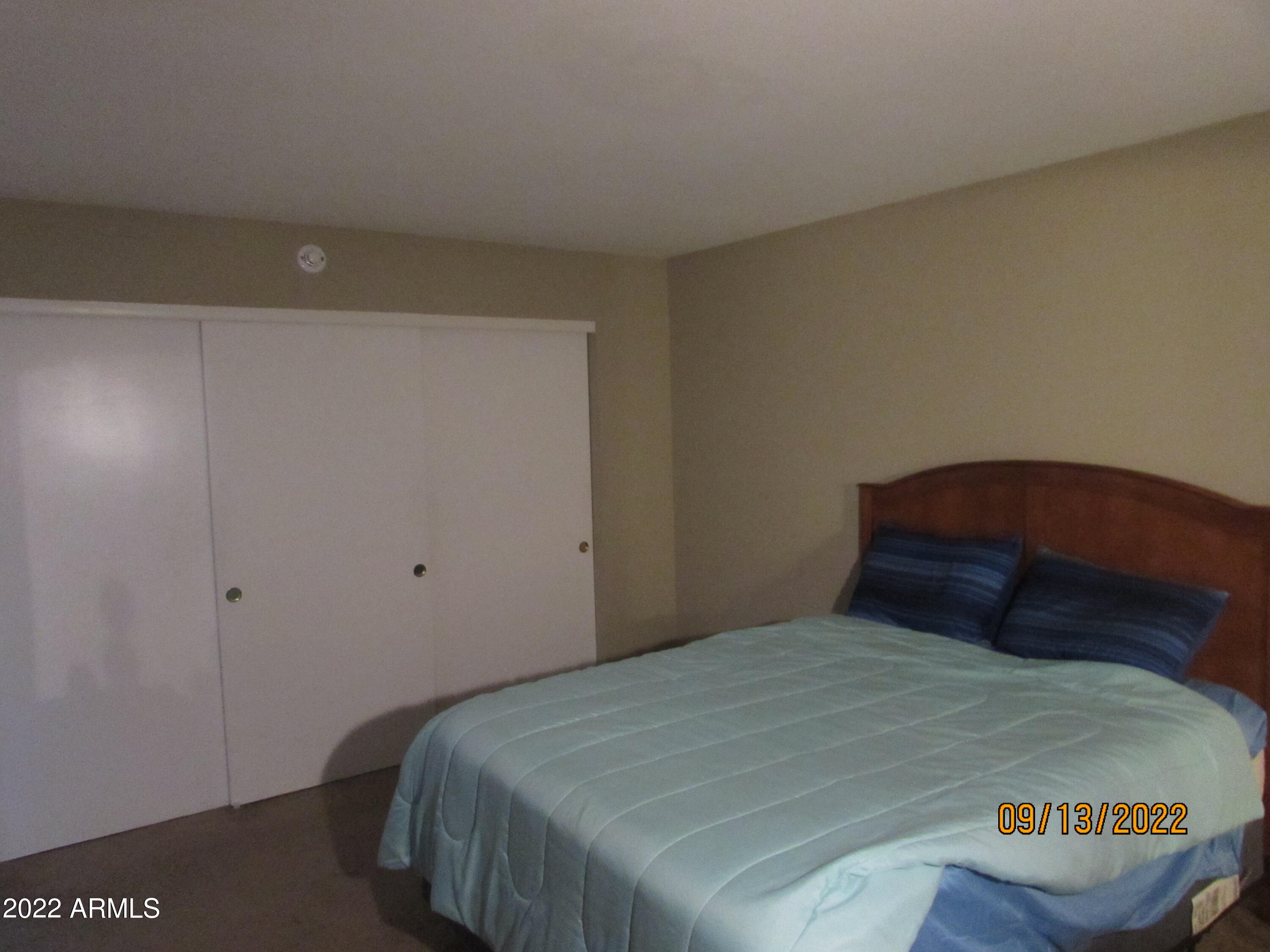 5236 West Peoria Avenue, Unit 115 Glendale, AZ 85302 - Photo 5 of 19 a bedroom with a bed and a night stand