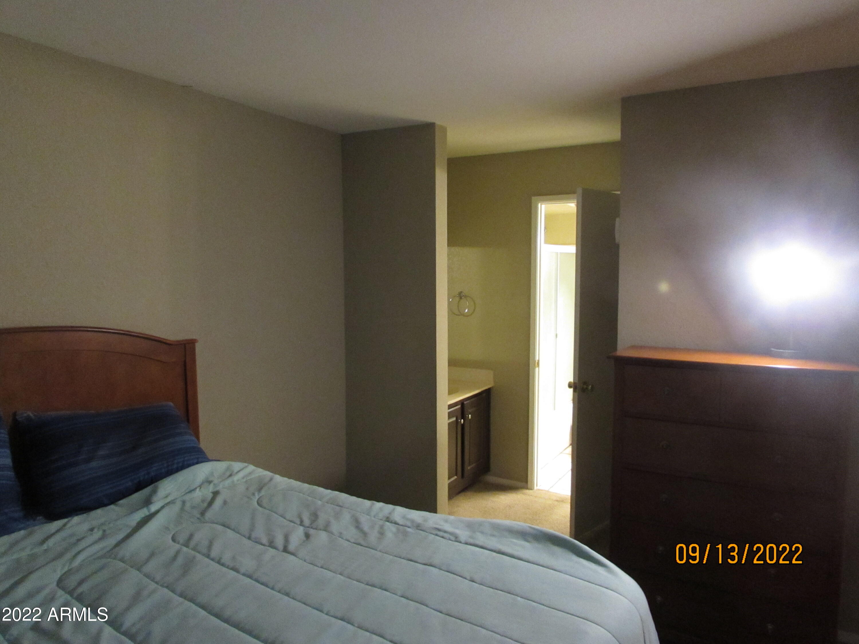 5236 West Peoria Avenue, Unit 115 Glendale, AZ 85302 - Photo 6 of 19 a bedroom with a bed and a night stand