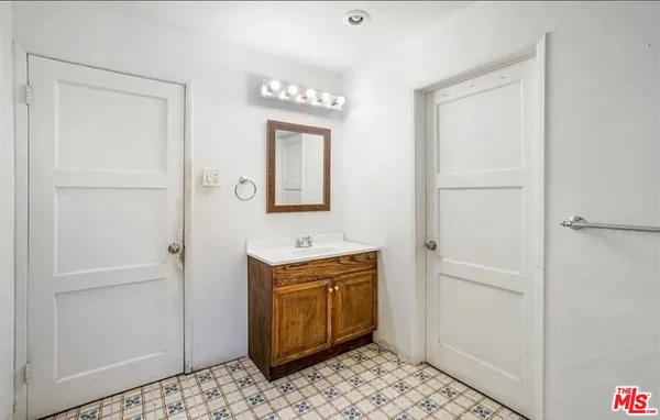 a view of a bathroom with mirror and sink