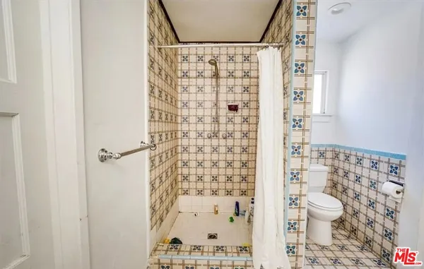 a bathroom with a toilet and a shower curtain