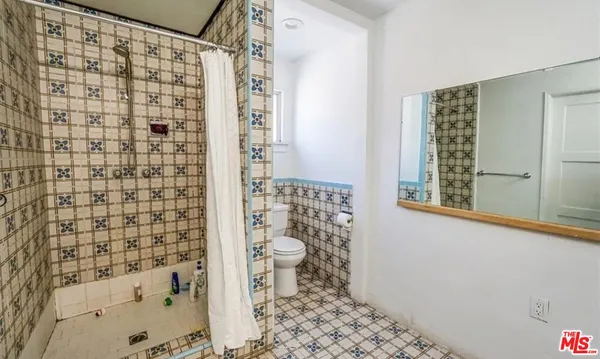 a bathroom with a toilet and a shower