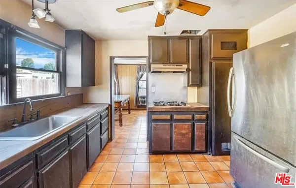 a kitchen with stainless steel appliances granite countertop a refrigerator a stove and a sink