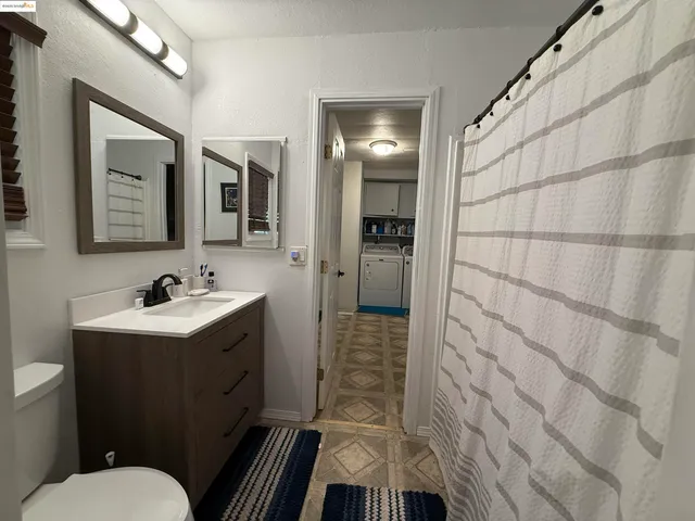 a bathroom with a granite countertop toilet sink and mirror