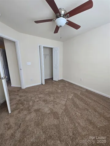 en empty room with ceiling fan and window