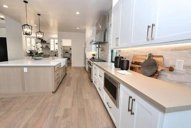 a kitchen with stainless steel appliances a dining table chairs and wooden floor