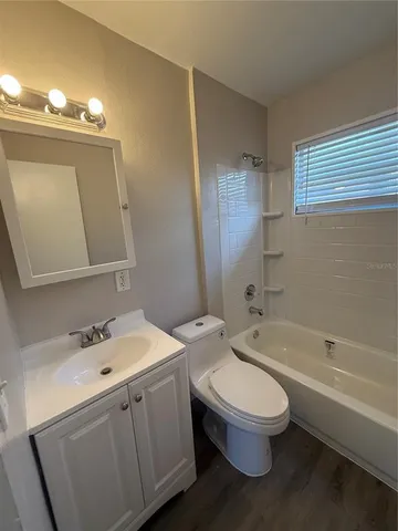 a bathroom with a toilet a sink a tub and mirror