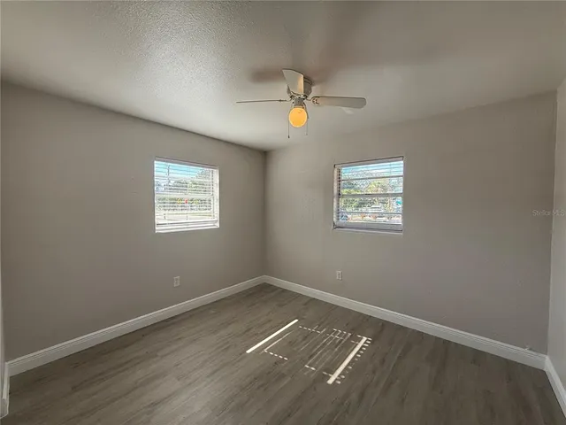 a view of room with hardwood floor and ceiling fan