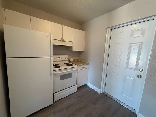 a white refrigerator freezer and a stove sitting inside of a kitchen