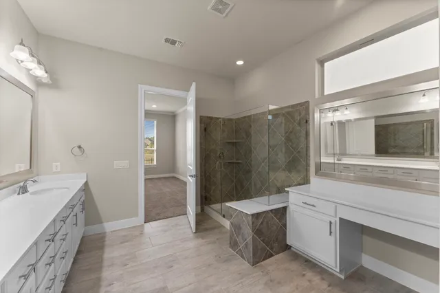 a bathroom with a double vanity sink a large mirror and a bathtub