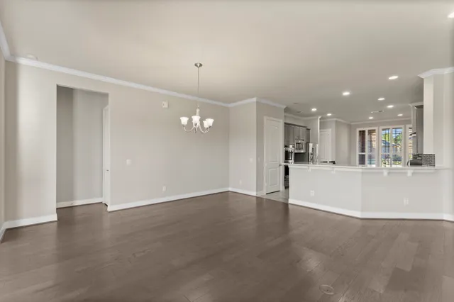 a view of a big room with wooden floor and windows
