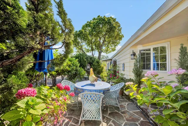a front view of a house with table and chairs and potted plants