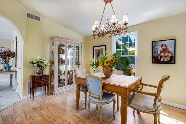 a view of a dining room with furniture a chandelier and wooden floor