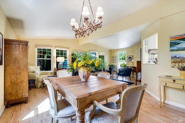 a view of a dining room with furniture a chandelier and wooden floor