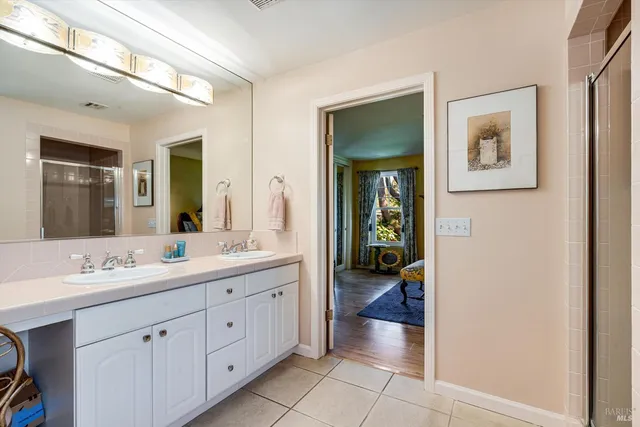 a en suite bathroom with a double vanity sink and a mirror