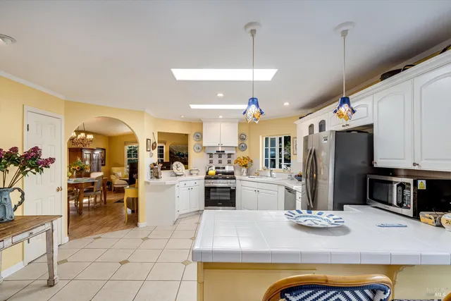 a kitchen with stainless steel appliances granite countertop a sink refrigerator and cabinets