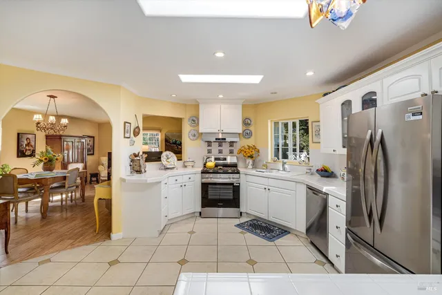 a kitchen with stainless steel appliances granite countertop a refrigerator and a stove top oven