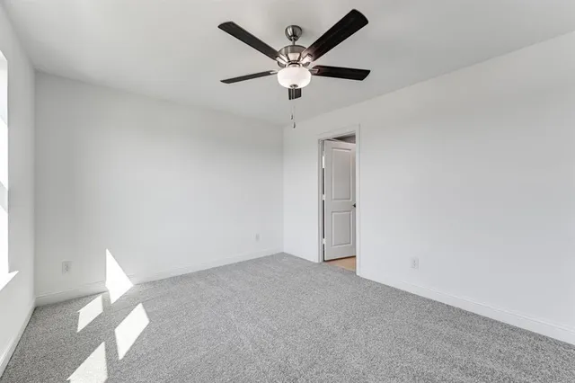an empty room with closet and ceiling fan