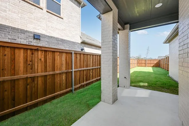 a view of a backyard with wooden fence