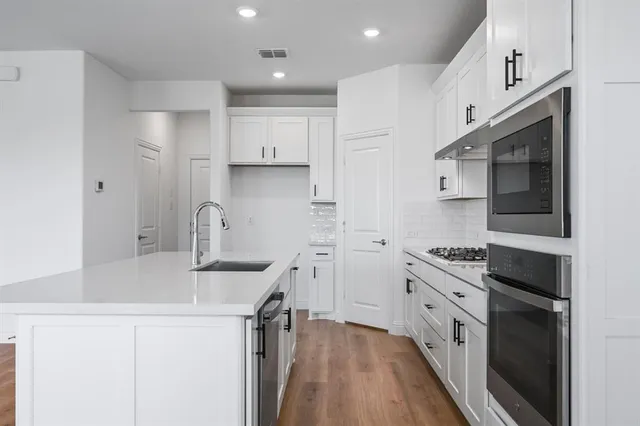 a kitchen with stainless steel appliances a sink stove and refrigerator