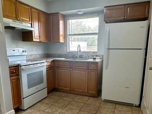 a view of a refrigerator and utility room in a kitchen