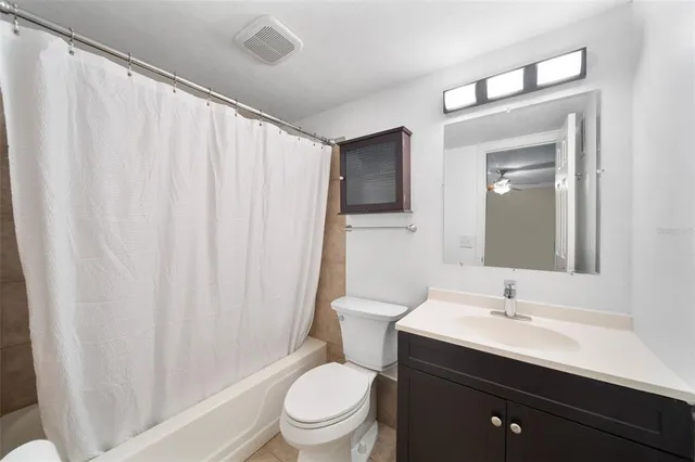 a bathroom with a sink a toilet a mirror and shower curtain