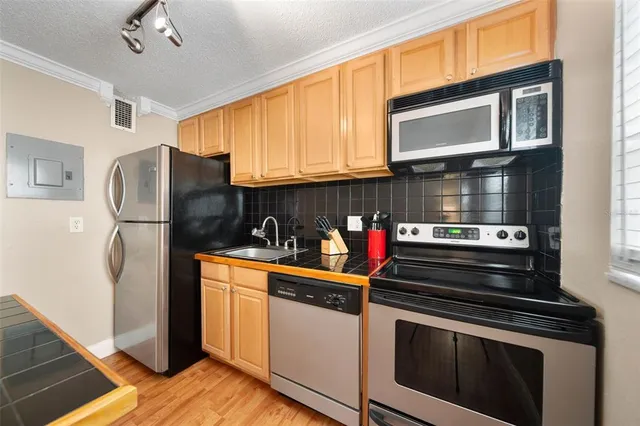 a kitchen with stainless steel appliances granite countertop a refrigerator stove and sink