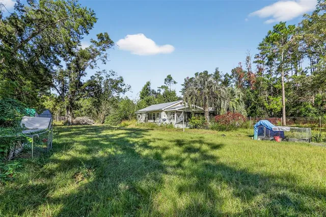 a view of a backyard with table and chairs and potted plants