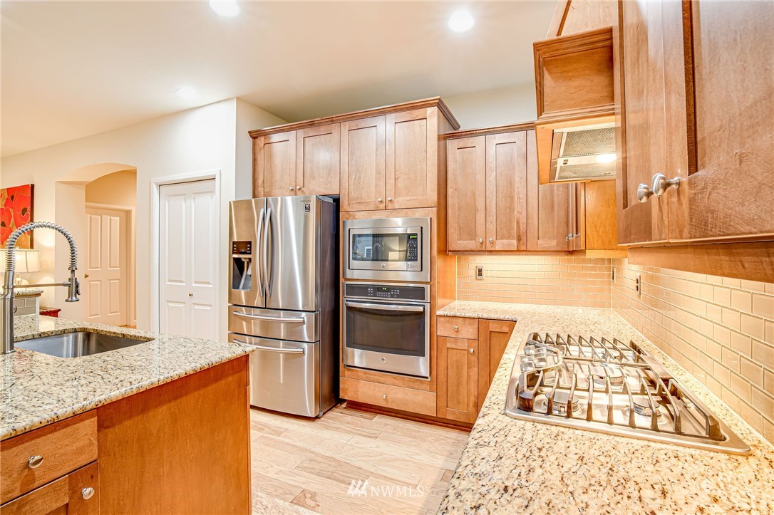 4025 181st Place Southeast Bothell, WA 98012 - Photo 5 of 26 a kitchen with stainless steel appliances granite countertop a refrigerator and a sink