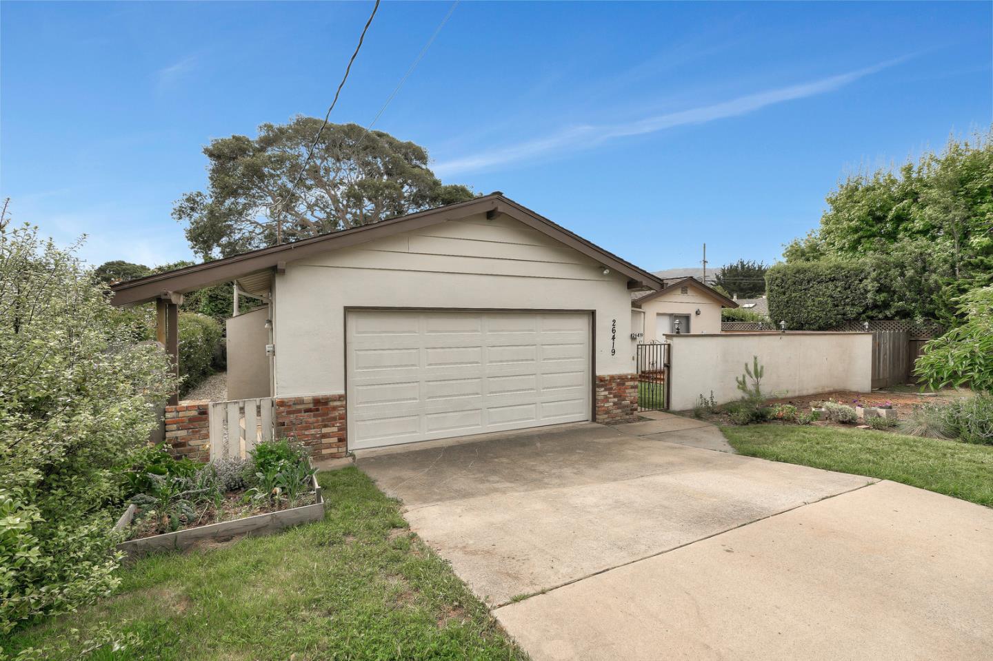 26419 Oliver Road Carmel, CA 93923 - Photo 2 of 35 a front view of house with yard and trees in the background
