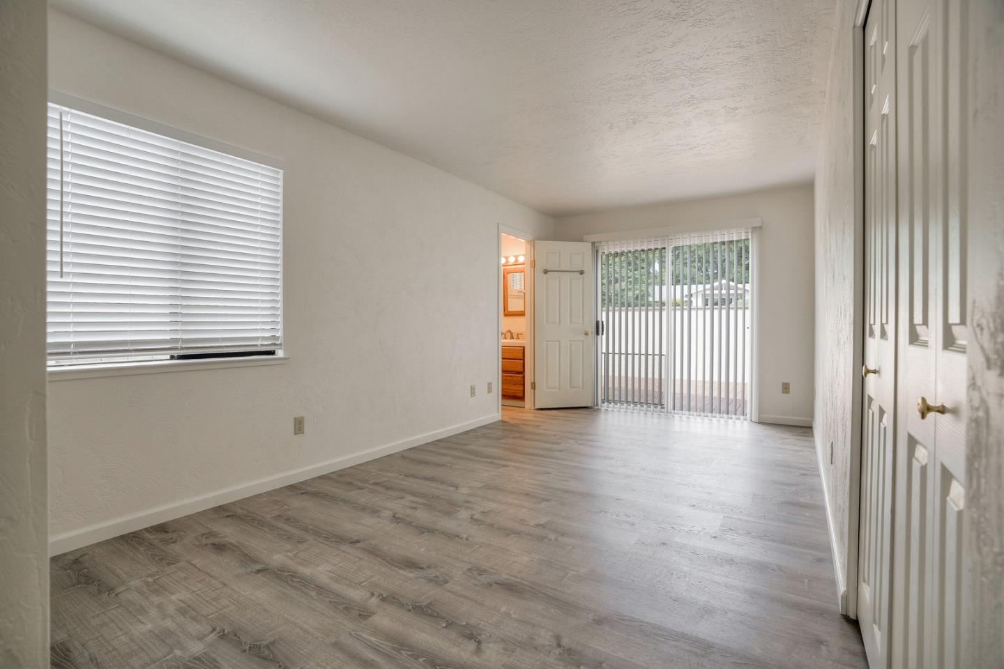 26419 Oliver Road Carmel, CA 93923 - Photo 24 of 35 an empty room with wooden floor and windows