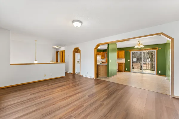 a view of an empty room with window and wooden floor