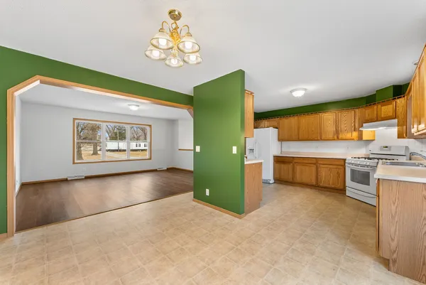 a large kitchen with stainless steel appliances granite countertop a stove a sink and a microwave