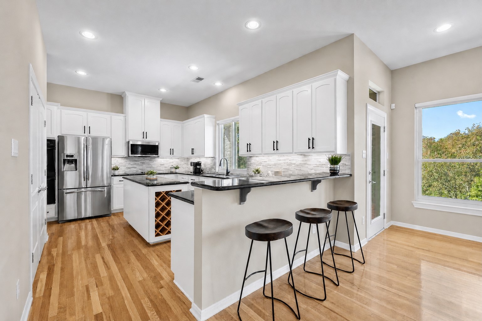 209 Overlook Court Georgetown, TX 78628 - Photo 13 of 34 a kitchen with stainless steel appliances kitchen island granite countertop a stove a sink a refrigerator and white cabinets with wooden floor
