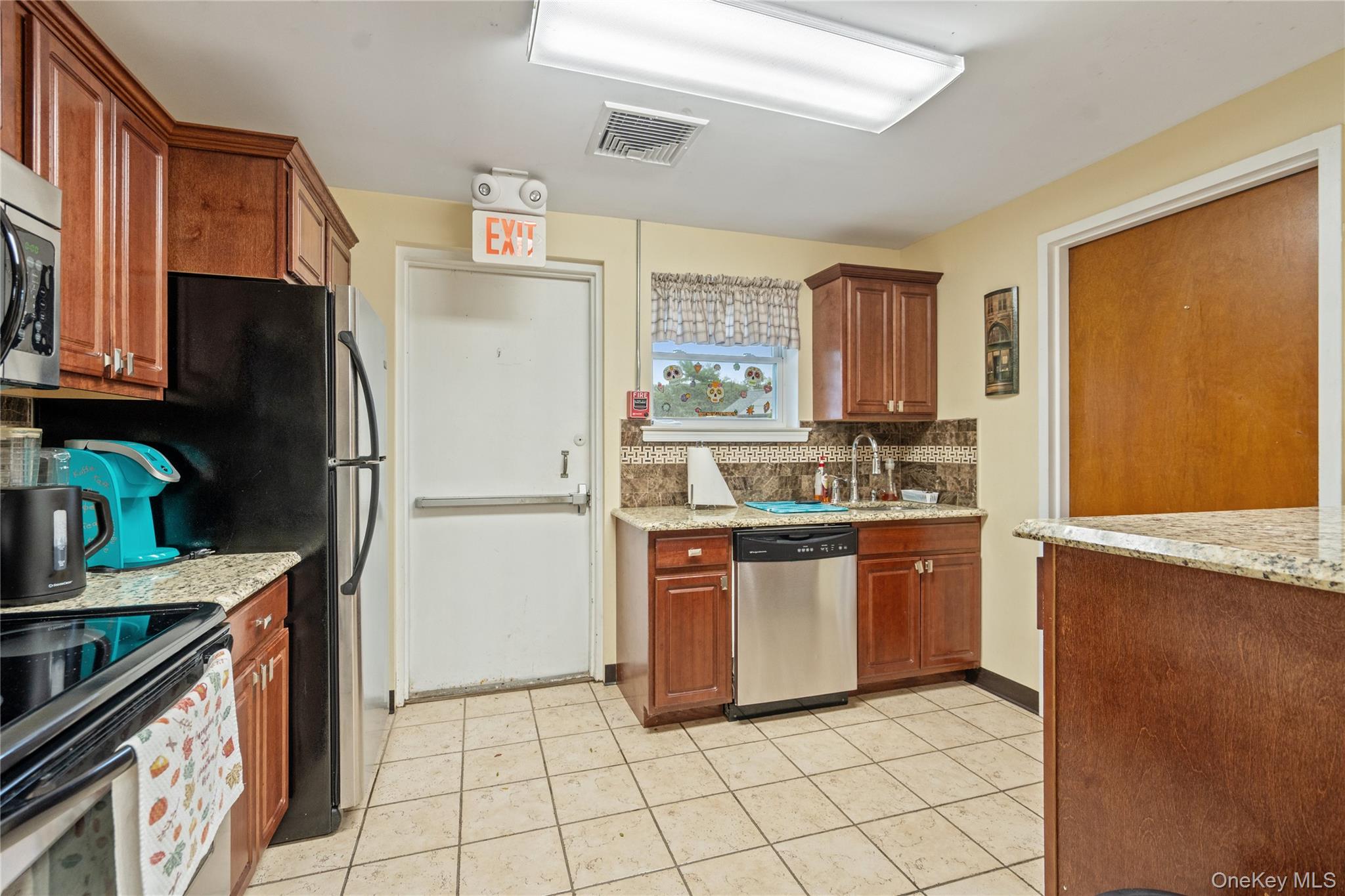 55 Forge Lane Coram, NY 11784 - Photo 25 of 28 a kitchen with stainless steel appliances granite countertop a refrigerator sink and stove