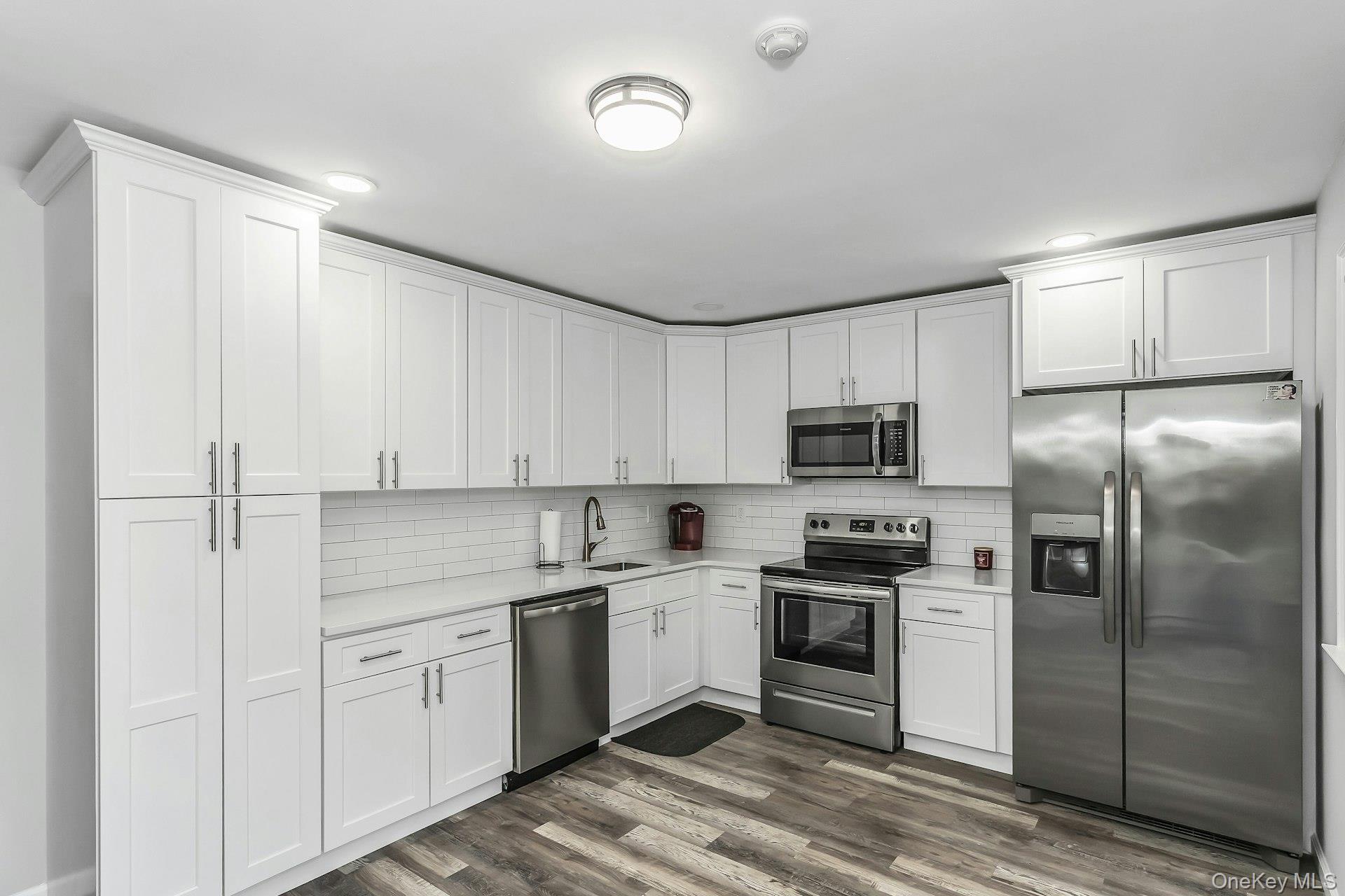 55 Forge Lane Coram, NY 11784 - Photo 8 of 28 a kitchen with a refrigerator sink and cabinets