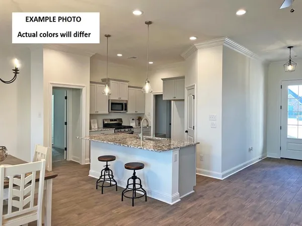 a view of a kitchen with kitchen island granite countertop wooden floor and a refrigerator