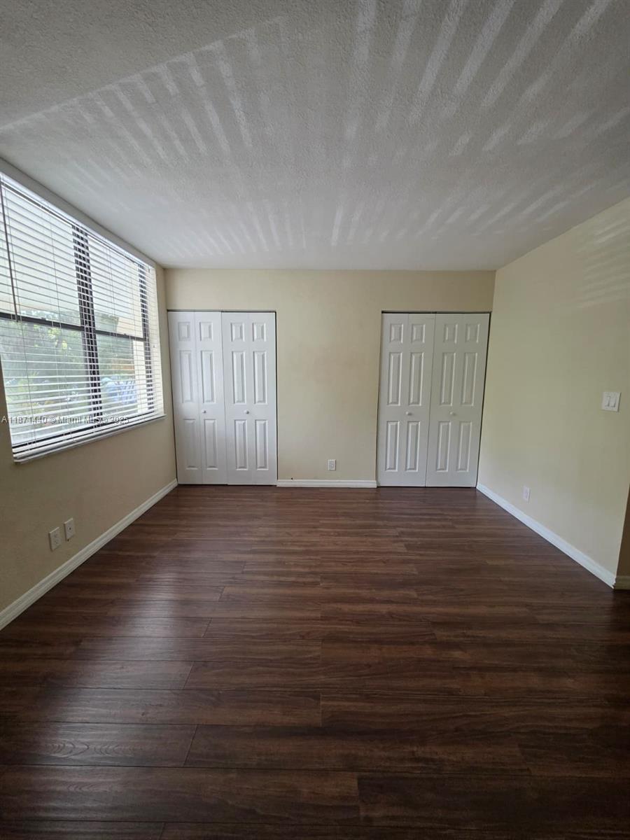 20200 West Country Club Drive, Unit 104 Aventura, FL 33180 - Photo 21 of 43 an empty room with wooden floor and windows
