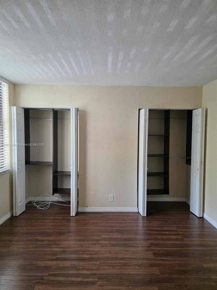 20200 West Country Club Drive, Unit 104 Aventura, FL 33180 - Photo 23 of 43 a view of an empty room with wooden floor and closet