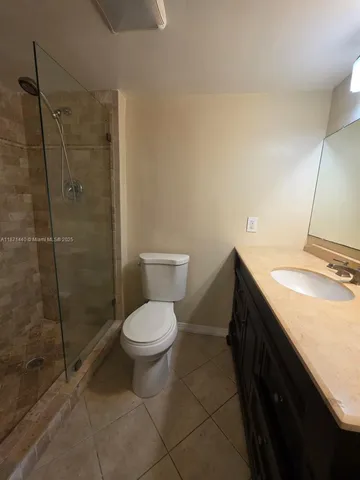 a white toilet next to a bathroom shower