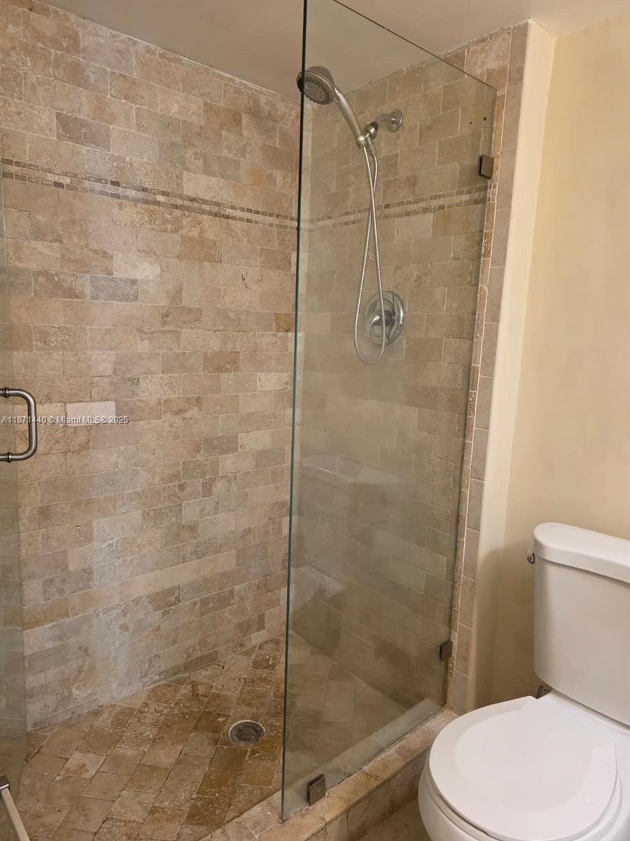 20200 West Country Club Drive, Unit 104 Aventura, FL 33180 - Photo 28 of 43 a white toilet next to a bathroom shower