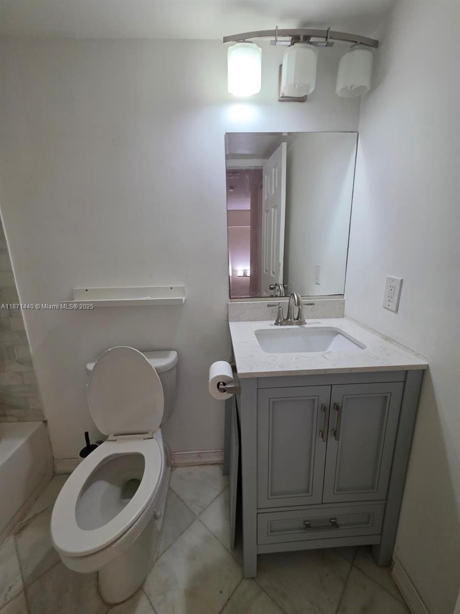 20200 West Country Club Drive, Unit 104 Aventura, FL 33180 - Photo 34 of 43 a bathroom with a sink toilet and mirror
