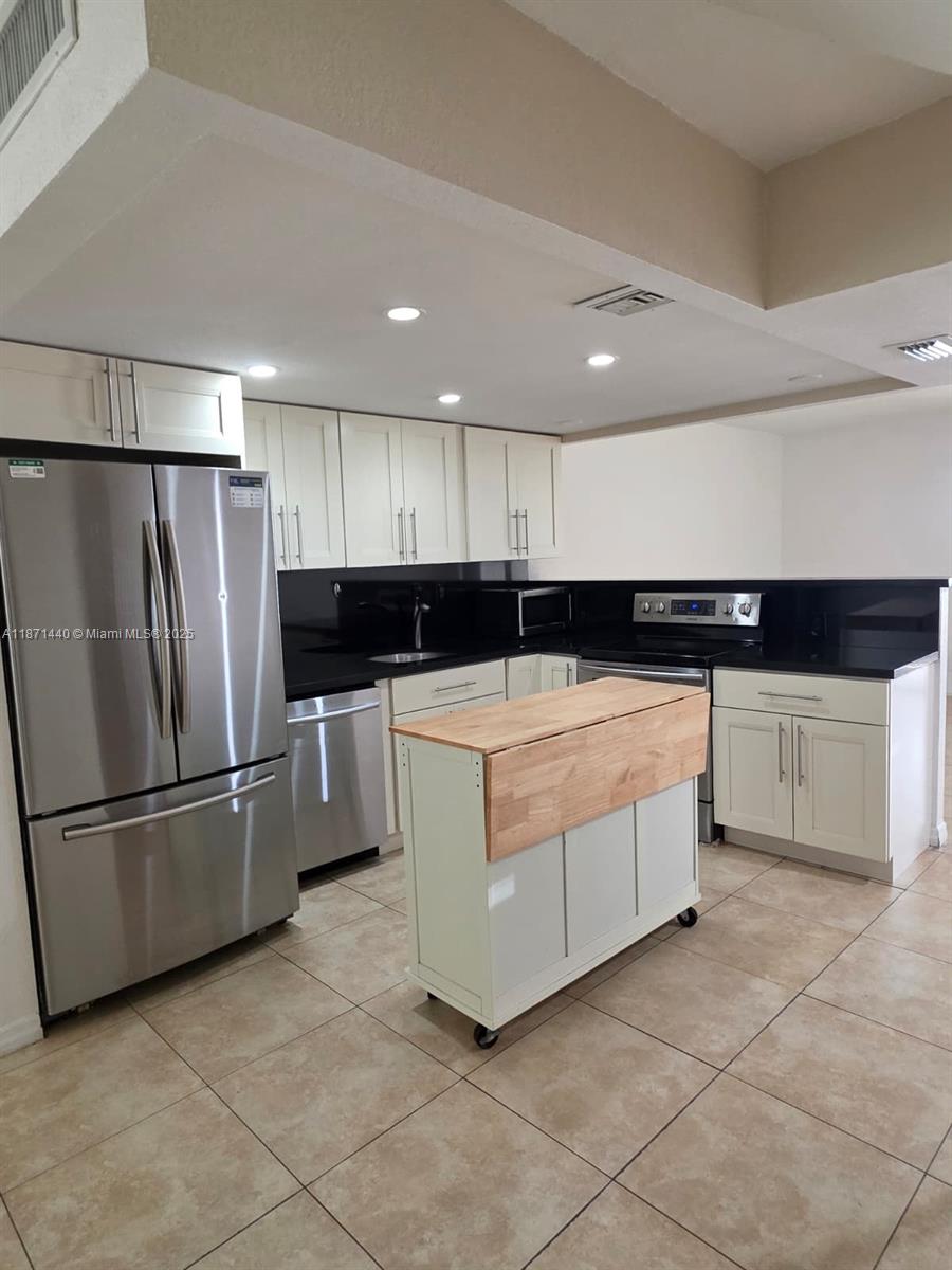 20200 West Country Club Drive, Unit 104 Aventura, FL 33180 - Photo 4 of 43 a kitchen with stainless steel appliances kitchen island granite countertop a refrigerator and a sink