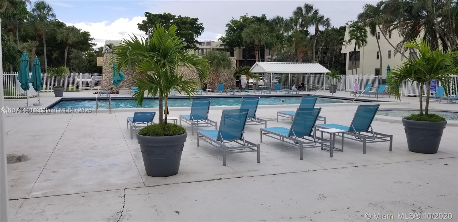 20200 West Country Club Drive, Unit 104 Aventura, FL 33180 - Photo 42 of 43 a view of a patio with table and chairs potted plants and palm tree