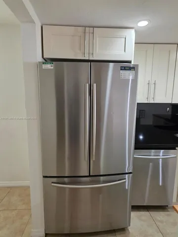 a metallic refrigerator freezer sitting in a kitchen